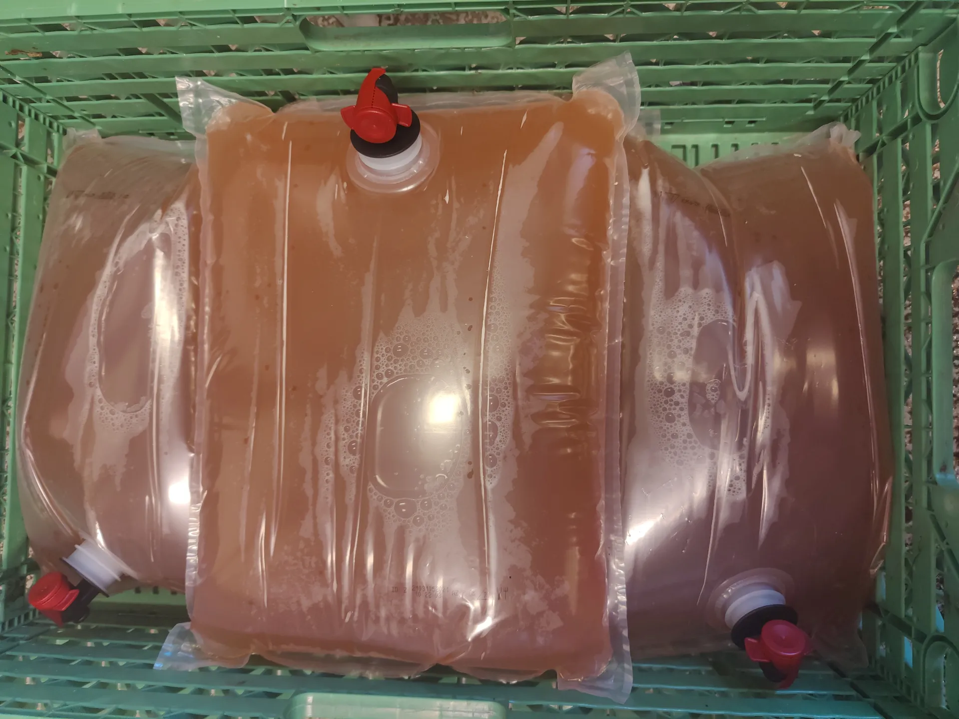 Sealed bags of finished apple juice stacked in a crate