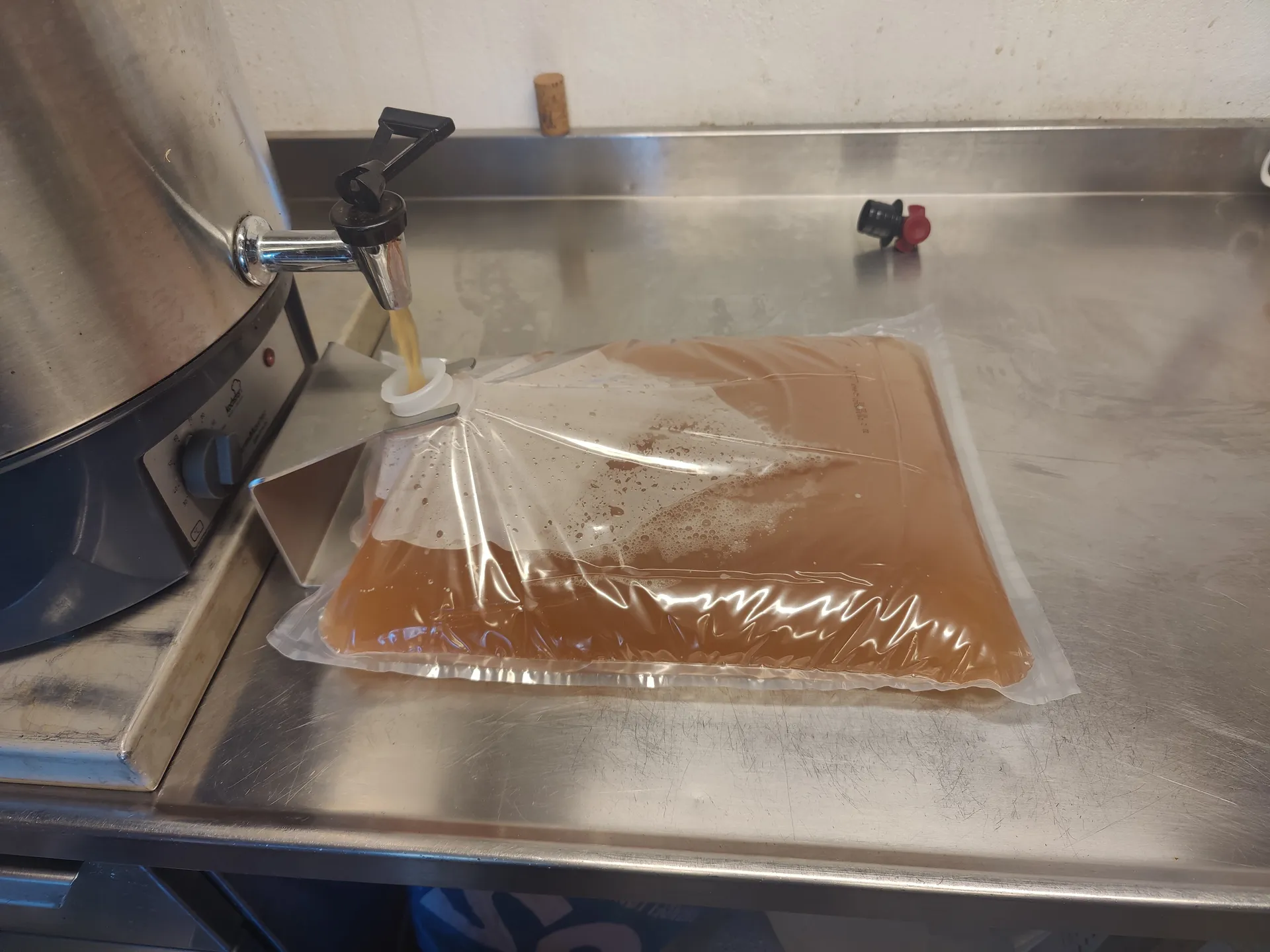 Fresh apple juice running from a tap into a bag-in-box